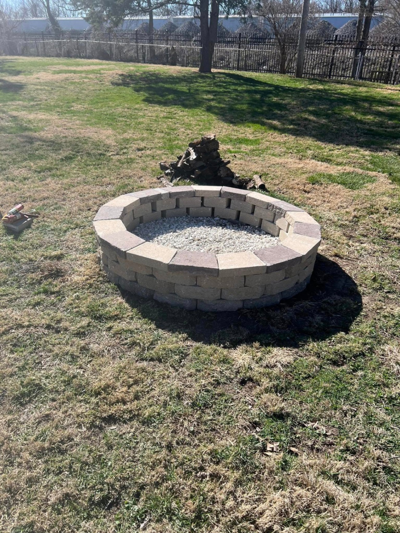 Clean rebuilt stone fire pit with white gravel